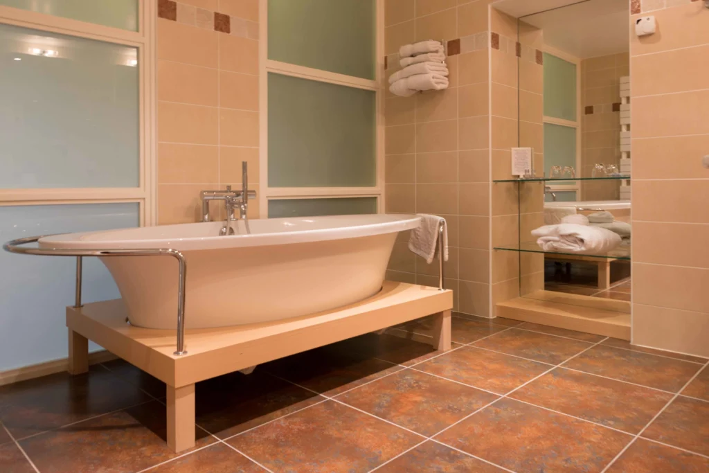 Salle de bain avec baignoire posée sur un socle en bois